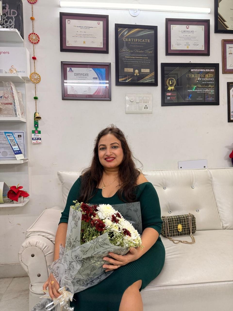 Dr Rajni Vardan Singh at Vardan Dental Clinic with selected training certificates displayed behind her