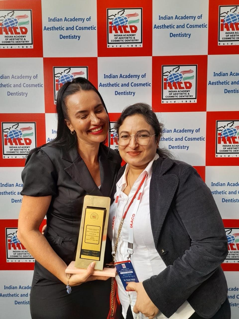 Dr Rajni Vardan Singh receiving professional recognition at an Indian Academy of Aesthetic and Cosmetic Dentistry event